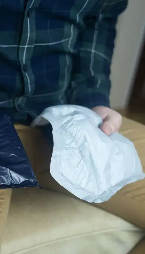 Image of man holding incontinence pads as part of overactive bladder treatment Cambridge